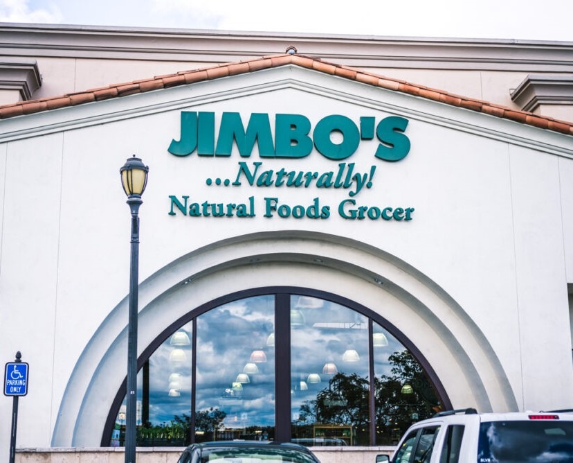 Photo of Jimbo's Grocery store front. "Jimbo's ... Naturally! Natural Foods Grocer is displayed in large green font above their store entrance.